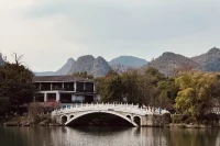 a bridge over water with a house in the background